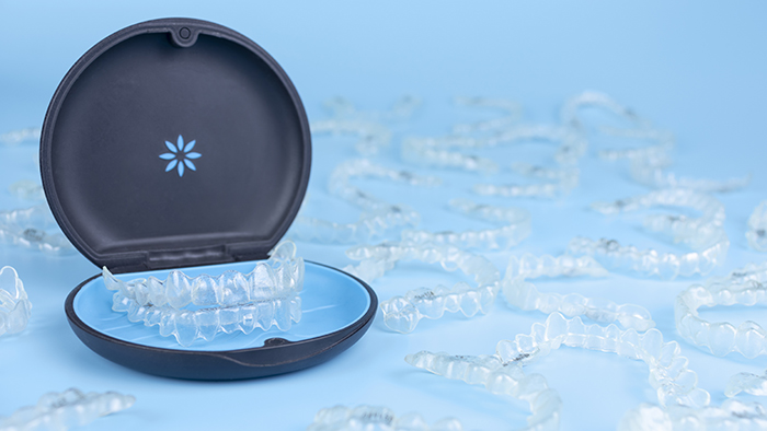 Invisible Retainers Case With Orthodontic Aligner Brackets. Black Plastic Dental Container For Removable Invisalign Braces On Blue Background